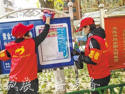 市第十一小學(xué)志愿者在擦拭宣傳欄。 本報記者 張?zhí)鸶?攝